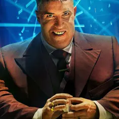 Złote zęby i złote pierścienie zdobią postać z obsady John Wick 4. W tle neonowe światła i stosy monet.