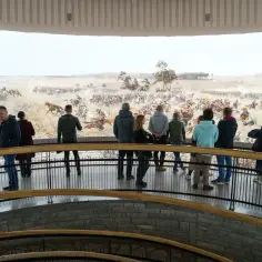 Widzowie podziwiający monumentalne dzieło, które przedstawia bitwę. Jan Styka i Wojciech Kossak to artyści, którzy namalowali Panoramę Racławicką.