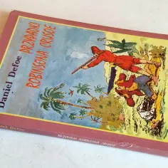 Okładka książki "Przypadki Robinsona Crusoe" Daniela Defoe. Ilustracja przedstawia dwie postacie na tle tropikalnej wyspy z palmami.
