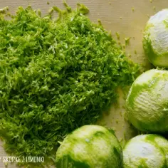 Świeżo starta skórka z limonek i kilka obranych limonek, idealne do przygotowania domowego kordiału limonkowego o smaku jak z baru.