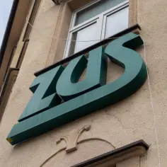 Zielone logo ZUS na budynku. Czekam na przelew, kiedy ZUS wypłaca L4.
