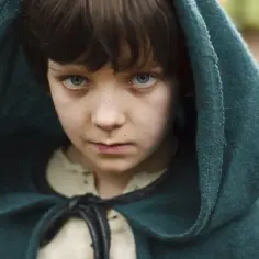 Chłopiec w kapturze, Asa Butterfield, znany z filmów, seriali i programów, z niebieskimi oczami i piegami.