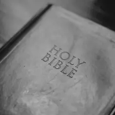 Stara Biblia, z wyrytymi literami "HOLY BIBLE". Może zawierać skróty biblijne, które pomagają w szybkim odnajdywaniu fragmentów.