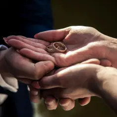 Dłonie trzymają dwie złote obrączki. Waga przeciętnej obrączki jest niewielka, ale symbolizuje wielką miłość.