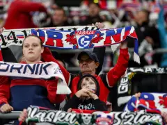 Kibice Górnika Zabrze na meczu z GKS Katowice. Widać szaliki z napisem "Górnik Zabrze" i herbem klubu.