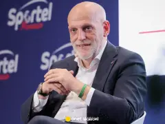 Uśmiechnięty Javier Tebas, prezes La Liga, w garniturze, na tle logo Sportel Forum.