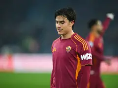 Piłkarz AS Roma w bordowej koszulce z pomarańczowymi pasami, gotowy do gry przeciwko Atalancie.