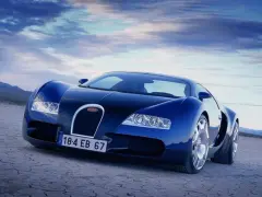Niebieski Bugatti Veyron na pustynnym tle pod błękitnym niebem.