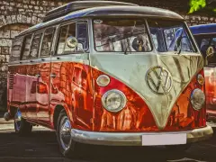 Klasyczny VW Transporter, idealny do transportu gości weselnych. Jego jaskrawy, dwukolorowy lakier przyciąga wzrok.