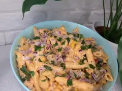 Penne z sosem gyros, kukurydzą i czerwoną cebulą, posypane natką pietruszki. Pyszna sałatka gyros z makaronem.