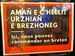 Cartel en bretón y francés: "Aquí puedes pedir en bretón". Un festival en Bretaña, Francia.
