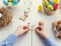 Ręce tworzą ozdobę wielkanocną z kurczakiem, inspirując do tego, jak zrobić koszyczek wielkanocny z filcu.