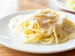 Pyszny makaron spaghetti polany kremowym sosem serowym, gotowy do podania.
