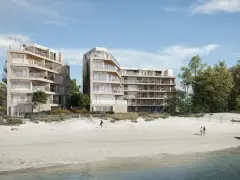 Nowoczesne apartamenty nad morzem, które mogą stracić na wartości od 2026 roku. Widok na plażę i budynki z balkonami.