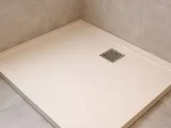 Un receveur résine ou céramique moderne, épuré, avec une grille d'évacuation carrée. Parfait pour une douche à l'italienne.