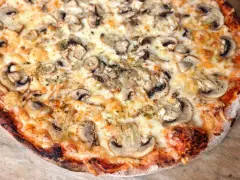 Pizza z pieczarkami i roztopionym serem, zrumieniona skórka.