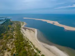 Piaszczyste plaże i zieleń tworzą malowniczy krajobraz, typowy dla nadmorskich miejscowości Polski.
