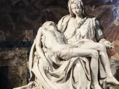Pieta Michała Anioła: Matka Boska trzyma na kolanach martwe ciało Jezusa. Marmurowa rzeźba zachwyca realizmem i emocjami.