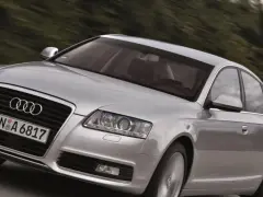 Silberner Audi A6 Limousine 2005 fährt auf einer Landstraße.