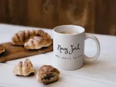 Kawa i croissanty, idealne na śniadanie. Kubek z napisem "Nowy Jork, mój koniec świata" to świetny pomysł, co kupić w USA do Polski.