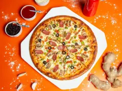 Pyszna pizza z kiełbasą, pieczarkami i papryką, obok sosy i imbir – idealne dodatki do pizzy.