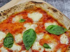 Ein Stück italienische Pizza Margherita mit geschmolzenem Mozzarella, Tomatensauce und frischem Basilikum. Perfekt für ein authentisches italien pizza rezept.