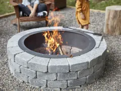 A stone fire pit with a roaring fire, perfect for a backyard gathering. This image shows how to build a fire pit for cozy evenings.