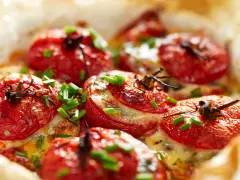 Pomodori ripieni al forno, dorati e succosi, con formaggio fuso e erba cipollina. Un'idea gustosa per un antipasto o un contorno.