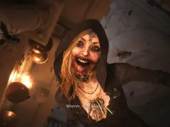 Przerażająca postać z Resident Evil Village, otoczona przez muchy, z krwią na ustach. Czas gry wciąga w mroczny świat.