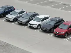 Rząd siedmiu SUV-ów zaparkowanych na placu.