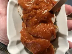 Eine Portion Currywurst mit viel Sauce, die Lust auf das Currywurst Rezept macht.
