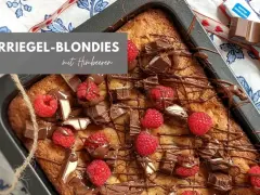 Kinderriegel-Blondies mit Himbeeren: Ein saftiger Kuchen, dekoriert mit Schokolade und frischen Beeren. Perfekt für das Blondies Rezept!
