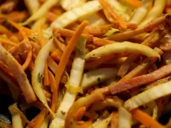 Pokrojone w słupki marchewka, fasolka i inne warzywa w daniu stir-fry.