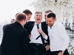 Śmiejący się pan młody otoczony przez przyjaciół. Świetne kawalerski pomysły na wspólne chwile przed ślubem.