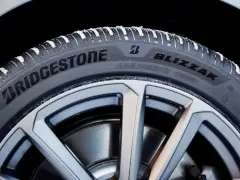 Opony zimowe Bridgestone Blizzak na feldze, pokryte śniegiem. Wiele pozytywnych opony Bridgestone opinie potwierdza ich jakość.