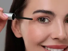 Kobieta aplikuje serum z bimatoprost na brwi, by uzyskać gęstszy efekt.