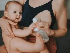 Mama karmi piersią i odciąga pokarm, pokazując, jak karmienie piersią a praca mogą iść w parze.