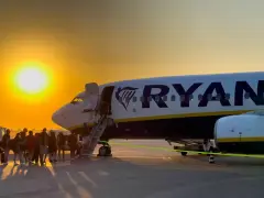 Ryanair loty za 1 zł – pasażerowie wsiadają do samolotu o zachodzie słońca.