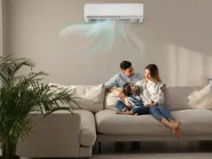 Famiglia felice sul divano, con l'aria condizionata che soffia aria fredda. Scopri come impostare condizionatore aria fredda per un comfort ottimale.