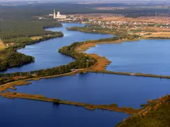 Widok z lotu ptaka na jezioro z wyspami, lasami i zabudowaniami w tle.
