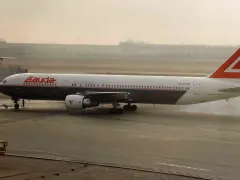 Samolot Lauda Air z charakterystycznym ogonem, kołujący po płycie lotniska.