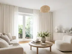 Ljust vardagsrum med en takmonterad gardinskena som elegant håller upp de böljande vita gardinerna.