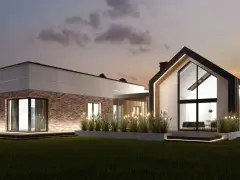 Nowoczesny dom z cegły i betonu z dużymi oknami, oświetlony wieczorem.
