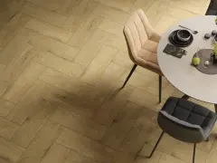 Eleganckie wnętrze z podłogą w jodełkę. Okrągły stół z krzesłami, nakryty do posiłku.
