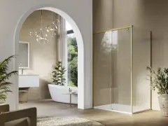 Mampara de ducha moderna con perfil dorado, un ejemplo de los tipos de mamparas de ducha que combinan estilo y funcionalidad en un baño elegante.