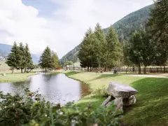 Passeggiata in bici ai laghetti di San Leonardo, tra alberi e montagne.