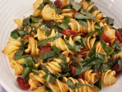 Fusilli conditi con bietole, salsiccia e un tocco di spezie. Un piatto saporito e colorato.