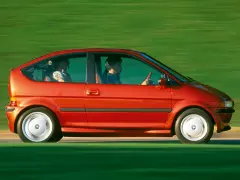 Czerwony samochód elektryczny BMW E1 z lat 90. jadący po zielonym tle.