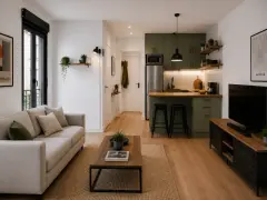Un loft pequeño moderno con sofá beige, mesa de centro de madera, cocina verde y TV.