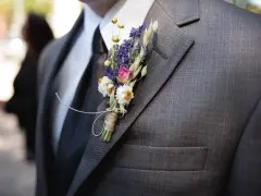 Elegancka butonierka co to? Bukiecik z suszonych kwiatów przyczepiony do marynarki.